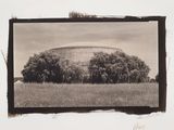 an old photo of a large building in a field with trees