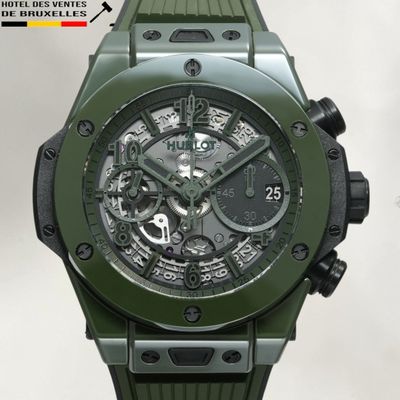 La montre est verte, avec un cadran noir et un bracelet en caoutchouc noir.