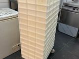 a stack of plastic containers sitting on a cart in a kitchen