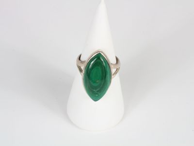 a close up of a ring with a green stone on it