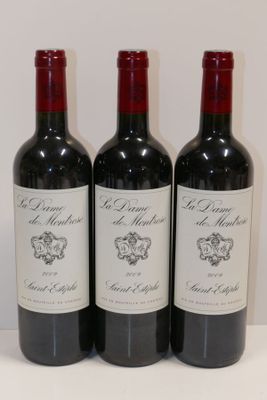 trois bouteilles de vin rouge sont alignées sur une surface blanche