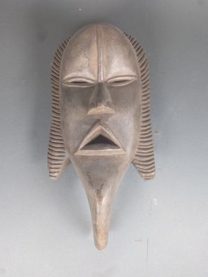 un gros plan d'un masque accroché au mur