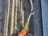 Une perceuse à fil de couleur orange est posée sur un établi en bois