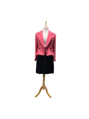 un mannequin vêtu d'une veste rose et d'une jupe noire