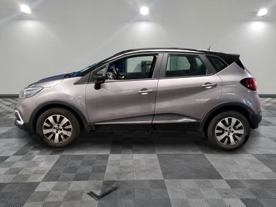 une voiture argentée est garée dans une pièce au sol en damier