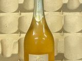 une bouteille de vin posée sur une table à côté d'un mur
