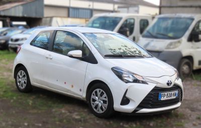 a white toyota yaris parked in a parking lot
