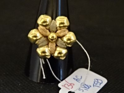 une bouteille de vin ornée de clochettes dorées et sur laquelle est accrochée une étiquette de prix