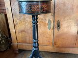 une petite table sur laquelle se trouve un tabouret, dans une pièce