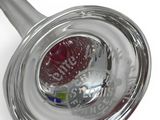 a silver spoon with a red handle on a white surface