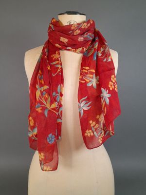 a red scarf on a mannequin torso with a red background