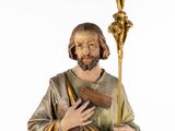 statue of jesus holding a cross and a book in his hand