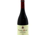the bottle of wine is sitting on a white surface