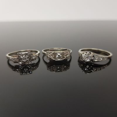 trois bagues de fiançailles ornées de diamants sur un fond noir