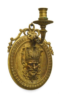 plaque en laiton sur laquelle figurent une tête d'homme et une bougie