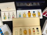 a lot of different perfumes in a box on a table