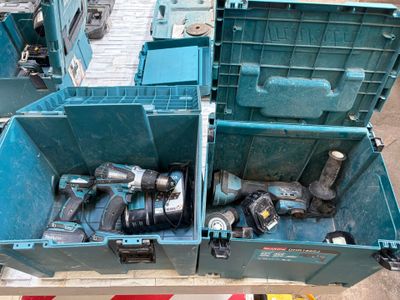 deux caisses bleues posées par terre, contenant des outils