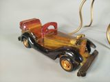 a wooden toy car with a red top and a gold handle