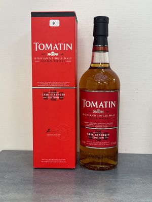 La bouteille de Tomatinn se trouve à côté de la boîte, sur la table.