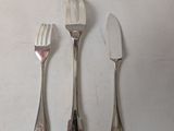 three forks and two spoons sitting on a table