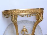a gold table with a statue on top of it
