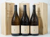 trois bouteilles de vin sont posées devant une caisse en bois