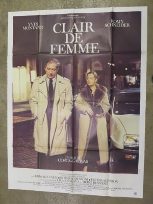an old movie poster of a man and a woman standing in front of a car
