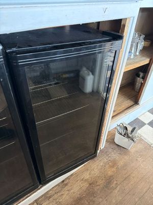 a black refrigerator in the corner of a kitchen