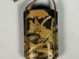 une vieille coque de portable à laquelle est accrochée une décoration en forme d'oiseau par son cordon