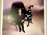 two men in suits standing next to a car