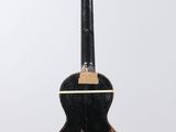a black and gold guitar hanging from a white wall