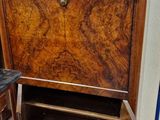 a wooden cabinet with a marble top in the corner of a room