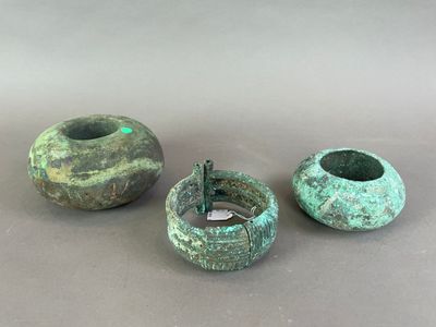 trois vases verts posés les uns à côté des autres sur une table