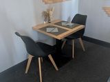 a table and chairs in a room with a mirror on the wall