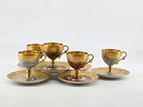six cups and saucers are sitting on a white surface