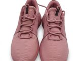 Les baskets roses des enfants sont posées sur une surface blanche