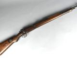 a rifle with a wooden barrel on a white surface
