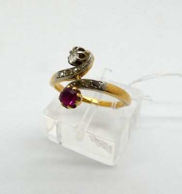 a close up of a gold ring with a ruby and diamond