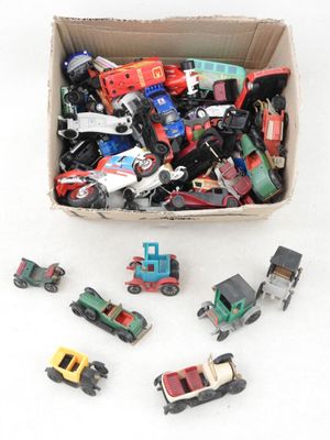 une boîte remplie de petites voitures de toutes sortes posée sur une surface blanche
