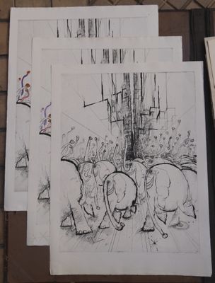 Plusieurs dessins d'éléphants sont posés sur une table, à côté d'une feuille de papier