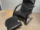 une photo représentant une chaise noire et un pouf dans une pièce