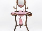 a pink vanity with a mirror and a pink vase