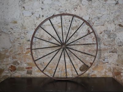une grande roue métallique posée sur une table en bois