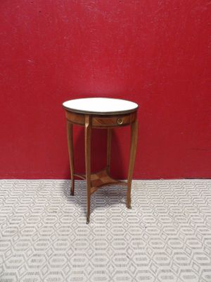 a small table with a white top in front of a red wall