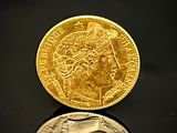 une pièce d'or et une pièce d'argent posées sur une surface noire