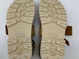 the soles of a pair of brown sandals on a white surface