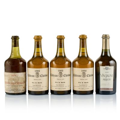 six bottles of wine are lined up on a white surface