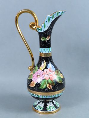 a black and gold vase with flowers painted on it