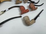 many different types of smoking pipes on the table