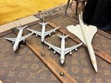 plusieurs maquettes d'avions posées sur une table en bois dans une pièce